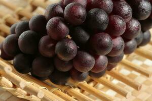 Clusters of ripe grapes on texture background photo