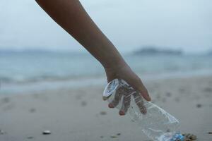 ahorrar agua. los voluntarios recogen basura en la playa y las botellas de plástico son difíciles de descomponer para evitar dañar la vida acuática. tierra, ambiente, planeta verde, reducir el calentamiento global, salvar el mundo foto