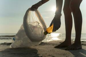 ahorrar agua. los voluntarios recogen basura en la playa y las botellas de plástico son difíciles de descomponer para evitar dañar la vida acuática. tierra, ambiente, planeta verde, reducir el calentamiento global, salvar el mundo foto