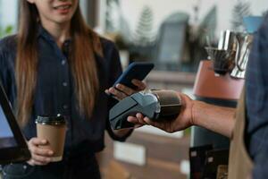 Woman use smartphone to scan QR code to pay in cafe restaurant with a digital payment without cash. Choose menu and order accumulate discount. E wallet, technology, pay online, credit card, bank app. photo