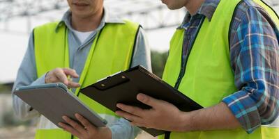 inspector or engineer is inspecting construction and quality assurance new house using a tablet. Engineers or architects or contactor work to build the house before handing it over to the homeowner photo