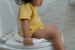 child going to the toilet, constipation in children, dyspepsia, abdominal pain, crying, defecating, straining, urinary incontinence, blood in the stool, bowel problems, ulcerative colitis, diarrhea photo