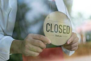 owner changed the sign from closed to open on the first day of business. guarantees safety, cleanliness, protective masks and open the coffee shop. open for New normal concept. photo