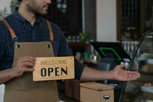 Business man owner show sign open on the first day of business. guarantees safety, cleanliness, open the coffee shop. open for New normal. Small business, welcome, restaurant, home made photo