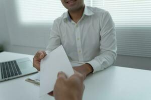 los empresarios reciben salarios o bonificaciones de la gerencia o del jefe. empresa dar recompensas para fomentar el trabajo. hombre de negocios sonriente disfrutando de una recompensa en el escritorio de la oficina. foto