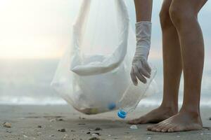 ahorrar agua. los voluntarios recogen basura en la playa y las botellas de plástico son difíciles de descomponer para evitar dañar la vida acuática. tierra, ambiente, planeta verde, reducir el calentamiento global, salvar el mundo foto