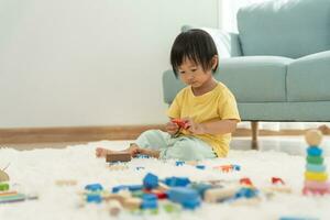 Happy Asian child playing and learning toy blocks. children are very happy and excited at home. child have a great time playing, activities, development, attention deficit hyperactivity disorder photo