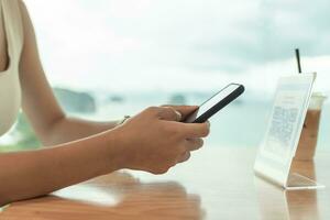 Woman use smartphone to scan QR code for order menu in cafe restaurant with a digital delivery. Choose menu and order accumulate discount. E wallet, technology, pay online, credit card, bank app. photo