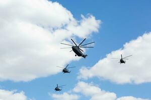 a group of four helicopters flying in the sky photo