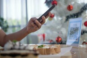 Woman use smartphone to scan QR code for order menu in cafe restaurant with a digital delivery. Choose menu and order accumulate discount. E wallet, technology, pay online, credit card, bank app. photo