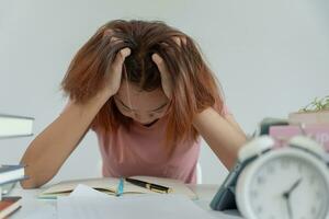 Asian student woman have anxiety because of exams, female prepare for test and learning lessons in the library. stress, despair, haste, misunderstanding reading, discouraged, expectation, knowledge photo