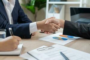 Executives are shaking hand after results success to target. financial data analysis and market growth report chart. Planning Strategies, startup project, profitable strategy, Business meeting time photo