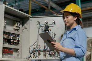 Mechanic or maintenance or electrical engineer checking main electrical control systems industrial plant. Utility fore man daily check power systems in process. Main Distribution Board, Switchboards photo