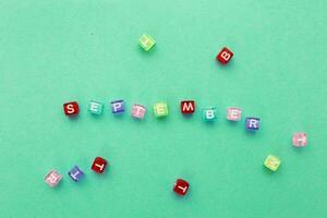 inscription September made by multicolor plastic cubes on a green background. photo