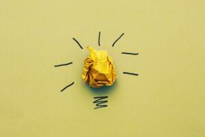 crumpled yelllow paper laightbulb as a concept creative idea and innovation photo