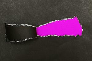 curl of torn black paper on pink background. advertising and sale concept. copy space photo