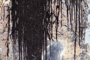Old rusty sheet metal smeared with black tar. Dark shabby rusty metal surface. photo