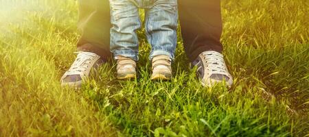 Father standing with his child boy in a summer park in nature outdoors. photo