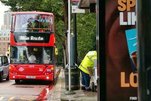 Gorgeous Low Angle view of Bus Service and British Traffic at Central London City of England UK. Image Captured on August 2nd, 2023 During Cloudy and Rainy Day. photo