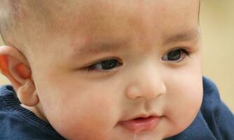 Close Up Shot of Cute Asian Pakistani 4 Months Old Baby Boy, Who is Enjoying at Home Garden at Luton City of England UK. Image Was Captured on July 23rd, 2023 photo