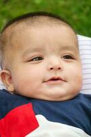 Close Up Shot of Cute Asian Pakistani 4 Months Old Baby Boy, Who is Enjoying at Home Garden at Luton City of England UK. Image Was Captured on July 23rd, 2023 photo