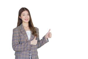 Young Asian professional woman with black long hair wearing plaid suit and pretty smiling looking at camera while present product thumbs up means good while isolated on white background. photo