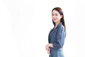 Professional young Asian business woman office worker who has long hair wears grey dress stand and smiles happily at office while isolated on white background. photo