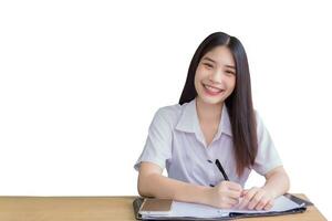 Portrait of adult Thai student girl. Beautiful Asian young woman student in uniform is writing documents for study smiling and looking at camera in university while isolated on white background. photo