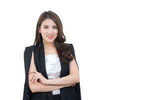 Young Asian working confident business woman who wears black suit and cross arms stands in white office room while working isolated on white background. photo