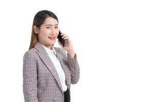 Professional young Asian business woman in formal suit with white shirt is use smartphone to calling telephone to check data while isolated on white background. photo