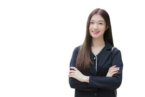 Beautiful young age Asian professional working female in black suit arms crossed and looks at the camera her smiling while walking outdoors to work at the office isolated on white background.. photo