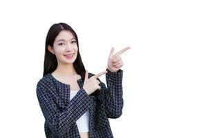 Young Asian working woman who wears black suit with braces on teeth is pointing hand to present something while isolated on white background. photo