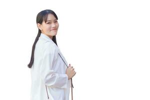 Confident young business Asian working female who wears white shirt and shoulder bag smiles happily while she is walking to work at office in city while isolated on white background. photo