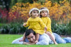 Young father having fun outdoors with his daughters. Fatherhood concept. Happiness concept. Family concept photo