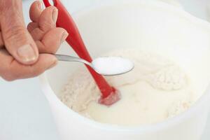 Home made pizza dough preparation. Adding sugar. Pizza preparation. photo