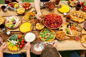 Homemade Romanian Food with grilled meat, polenta and vegetables Platter on camping. Romantic traditional moldavian food outside on the wood table. photo