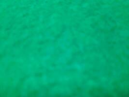 Defocused abstract carpet background in bright Tosca green color photo