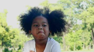 niña Bebiendo Leche desde un vaso deliciosamente niña sentado en el parque video