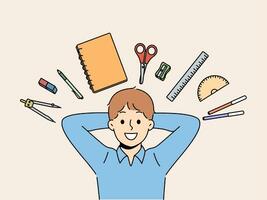Back to school concept, with boy lying among stationery for learning and gaining new knowledge photo
