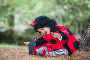 pequeño bebé niña vistiendo un mariquita traje. Víspera de Todos los Santos concepto. foto