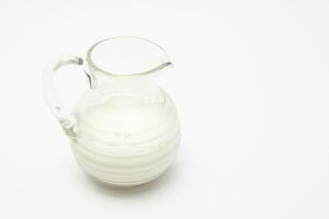 Glass jar full of milk isolated on white background photo