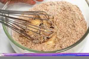 Wheat bran muffins preparation. Mixing ingredients to prepare integral wheat bran muffins photo