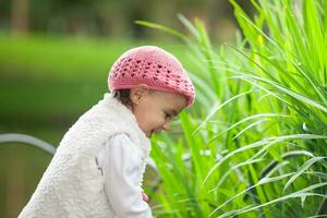 Sweet year and a half baby girl at the garden in a beautiful sunny day photo