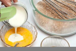 Wheat bran muffins preparation. Adding yogurt to the mix to prepare integral wheat bran muffins photo