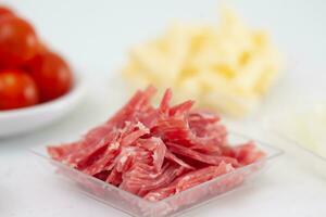 Salami pizza topping ingredients. Pizza preparation. photo