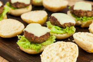 Step by step preparation of mini burgers. Homemade mini burgers for children or appetizers. Small hamburgers. Assembling burgers photo