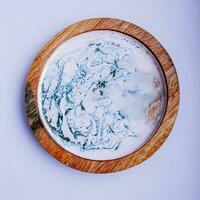 Handmade resin coaster with floral pattern on white background. Selective focus. photo