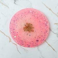Handmade resin coaster with floral pattern on white background. Selective focus. photo
