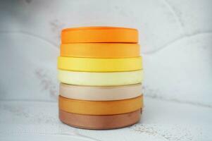 colorful ribbons stacked on a grey marbled background. Ribbon for handmade craft DIY photo