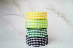 colorful ribbons stacked on a grey marbled background. Ribbon for handmade craft DIY photo